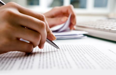A close up of a hand working on a document