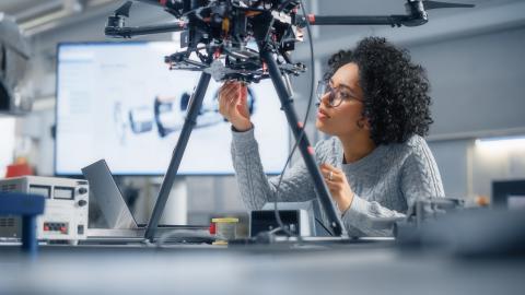 A Black woman engineer building a robot